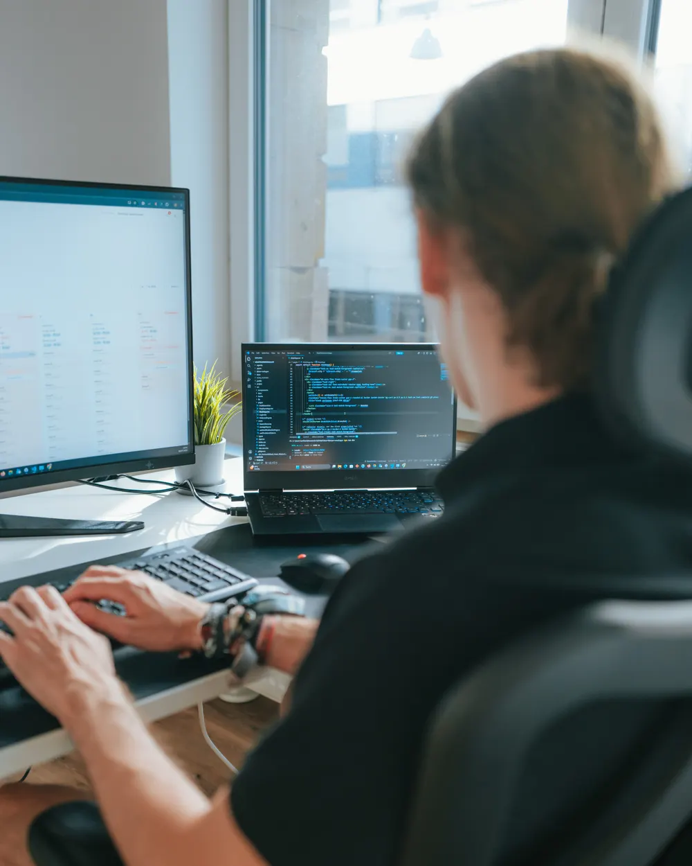 Blick über die Schulter auf den Arbeitsplatz bei Warp Solutions: Entwicklung einer Web-Anwendung an zwei Bildschirmen